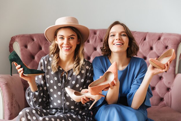 Gelukkige jonge vrouwen shopaholics die schoenen houden.