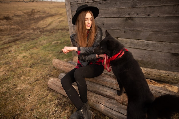 Gelukkige jonge vrouwenzitting met haar zwarte hond