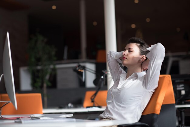 gelukkige jonge zakenvrouw die ontspant en inspiratie opdoet tijdens het werken op een desktopcomputer bij een modern, helder starup-kantoorinterieur