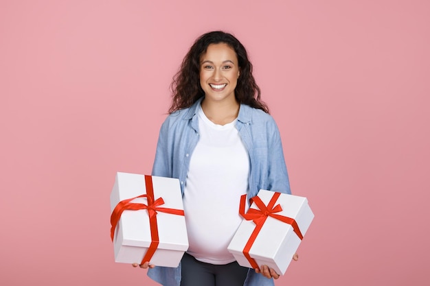 Gelukkige jonge zwangere vrouw met geschenkkistjes.