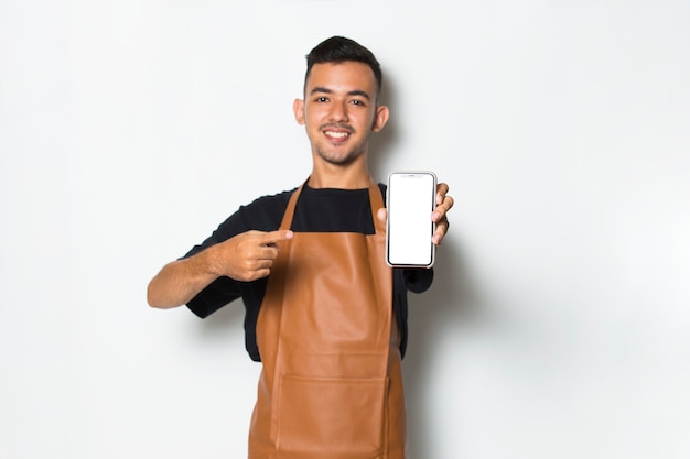 Gelukkige jongeman barista serveerster houdt mobiele telefoon vast met leeg leeg scherm