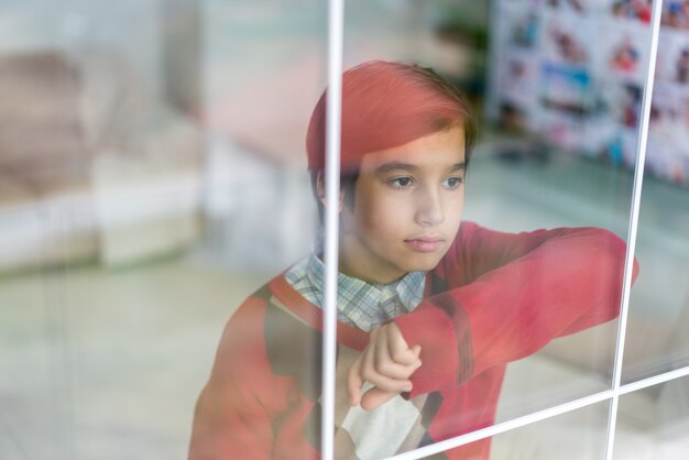 Gelukkige jongen achter vensterglas