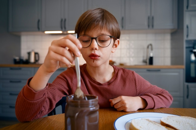 Gelukkige jongen die snoep eet op chocoladedag.