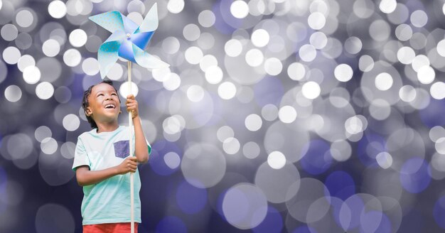 Gelukkige jongen die vuurrad over bokeh houdt