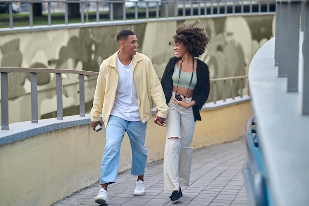 Gelukkige jongen en meisje lopen hand in hand