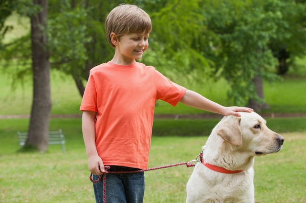 Gelukkige jongen met huisdierenhond bij park