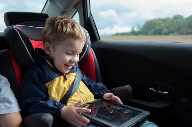 Gelukkige jongen speelt met touchpad in de auto