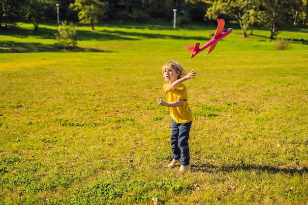 Gelukkige jongen spelen met speelgoed vliegtuig in het park.