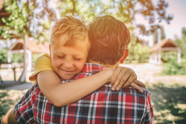 Foto gelukkige jongen zijn vader knuffelen