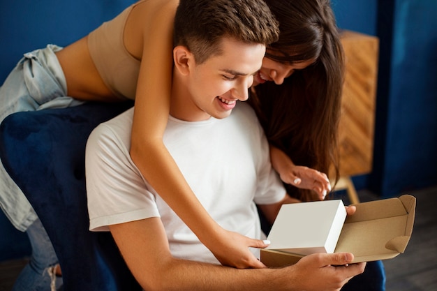 Gelukkige kerel met een vrouw die een wit leeg teken houdt