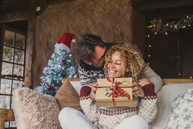 Gelukkige kerstmensen thuis die cadeau krijgen