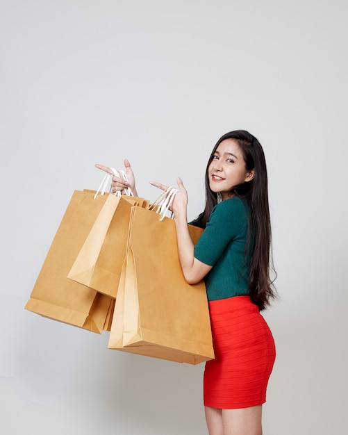 Gelukkige Kerstmis Aziatische vrouw het winkelen holdingsdocument zakken