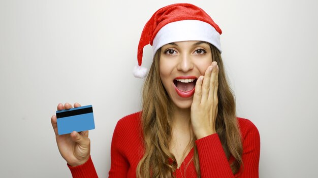 Gelukkige Kerstmisvrouw die het winkelen met creditcard doet