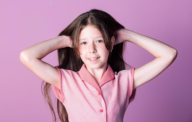 Gelukkige kinderdag schoonheidstips voor netjes haar onschuld concept zuivere schoonheid meisje lang gezond glanzend haar close-up klein meisje met lang haar kind schattig gezicht met schattig haar op roze achtergrond