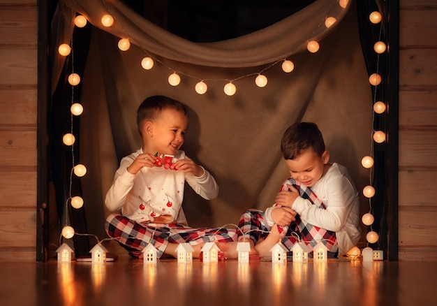 Foto gelukkige kinderen bij de kerstboom hebben plezier in het nieuwe jaar