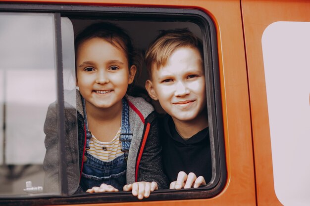 Gelukkige kinderen, broer en zus reizen met de auto Vakantie- en reisconcept