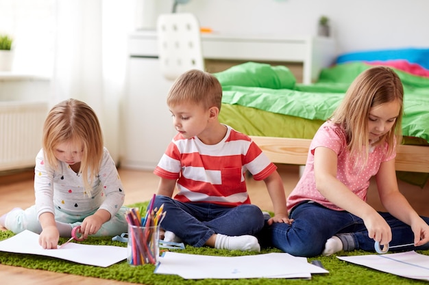 Gelukkige kinderen die thuis tekenen.