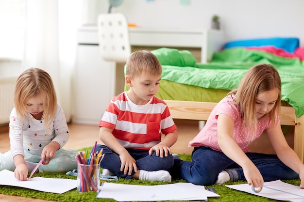 Gelukkige kinderen die thuis tekenen.