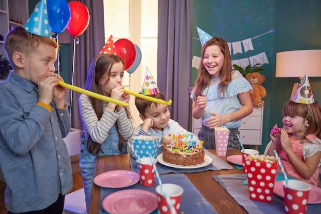 Gelukkige kinderen in partij caps vieren een verjaardag