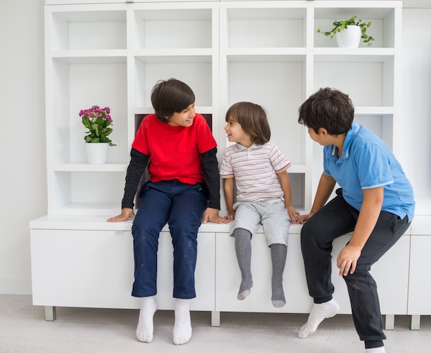 Gelukkige kinderen plezier hebben en poseren in nieuwe moderne woning