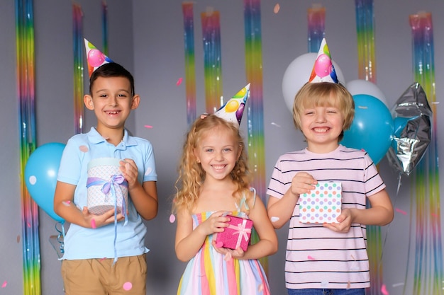 Gelukkige kinderen vermaken zich tijdens de vakantie en springen in kleurrijke confetti