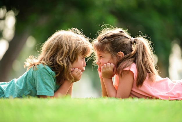 Gelukkige kinderen zijn dol op een paar kinderen die buiten op het gras liggen