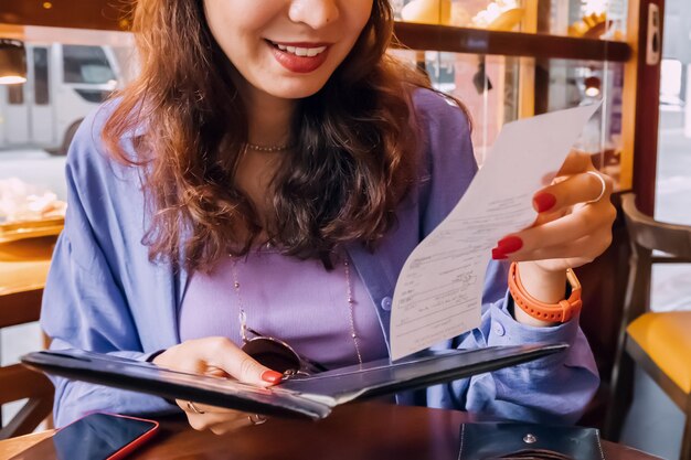 Gelukkige klant die na het diner in een luxe restaurant naar de factuur kijkt.