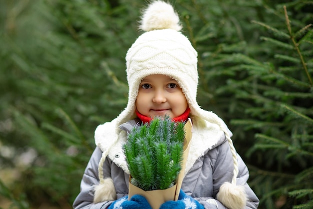 Gelukkige kleine glimlachende meisje staande met sparren takken vakantie vieren kerst concept