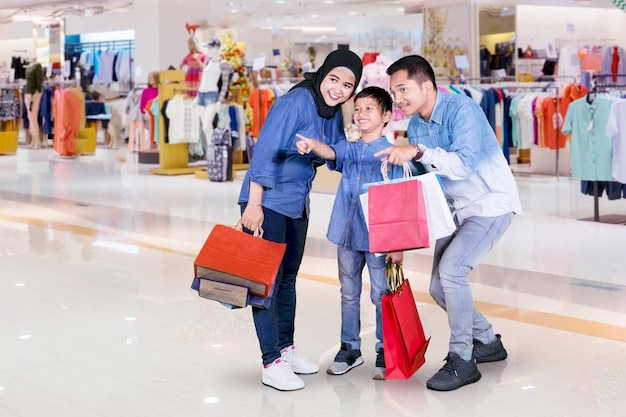 Gelukkige kleine jongen met zijn ouders in het winkelcentrum