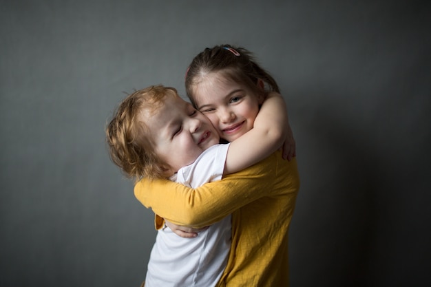 gelukkige kleine kinderen die elkaar knuffelen