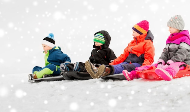 Foto gelukkige kleine kinderen glijden op slee in de winter.