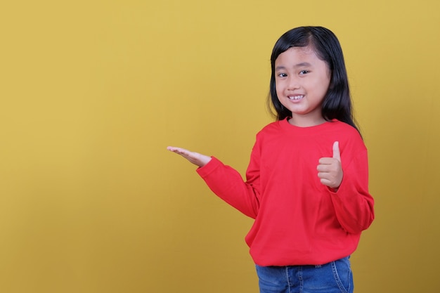 Gelukkige kleine kinderen glimlachen, iets laten zien en duimvinger geven