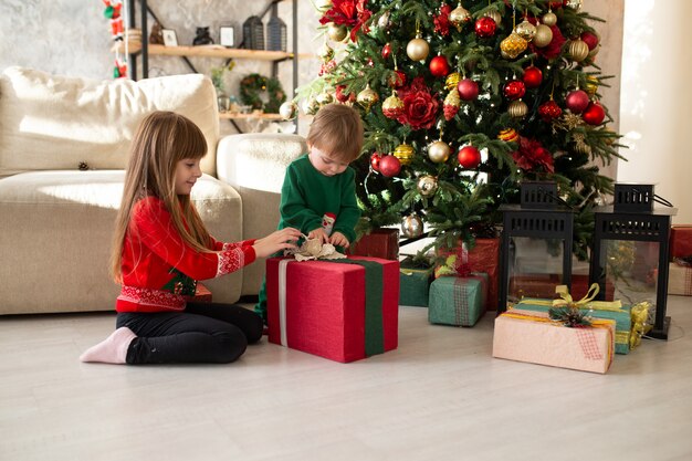 Gelukkige kleine kinderen met kerst geschenkdozen.