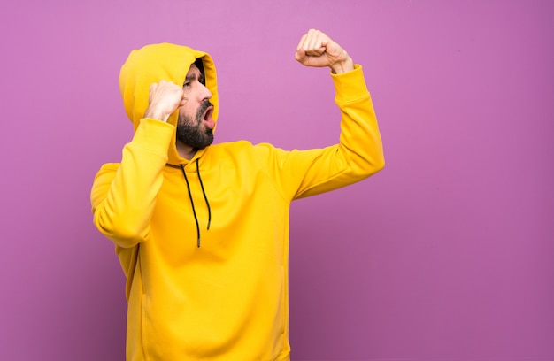 Gelukkige knappe man met gele sweater