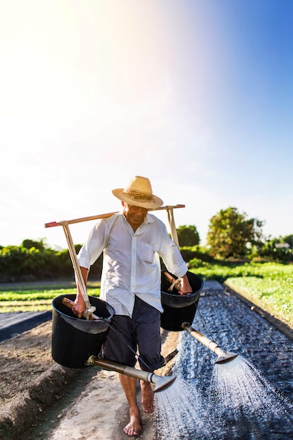 Gelukkige landbouwer het water geven van zijn planten