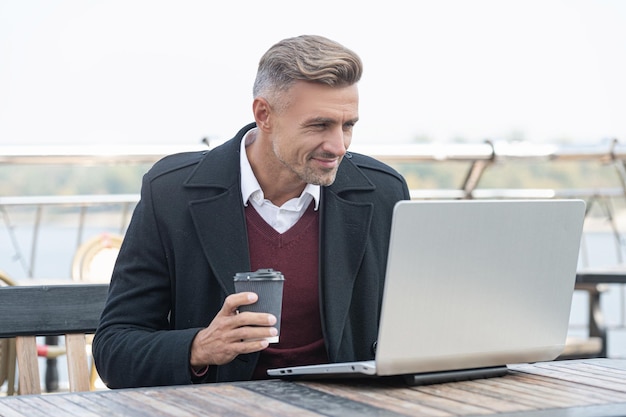 Gelukkige man blogger in formalwear bloggen zakelijke blog in laptop koffie drinken op terras