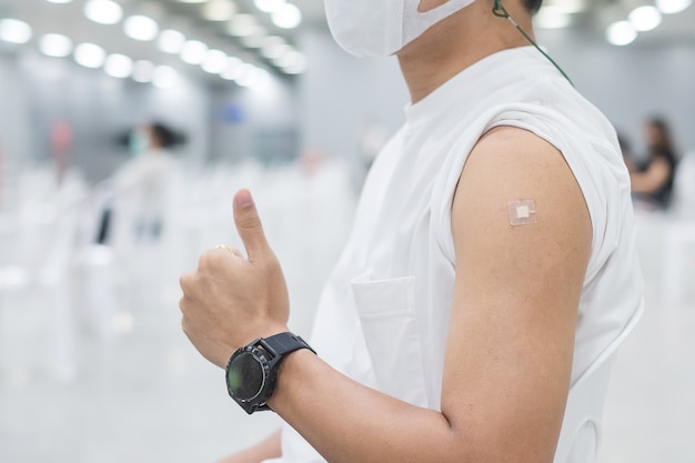 Gelukkige man die duim toont na ontvangst van vaccin. Vaccinatie, immunisatie, inenting en Coronavirus (Covid-19) pandemie