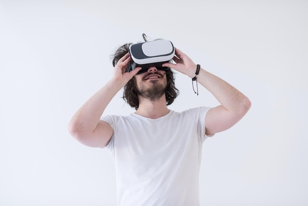 Gelukkige man die ervaring opdoet met het gebruik van een VR-headsetbril van virtual reality, geïsoleerd op een witte achtergrond