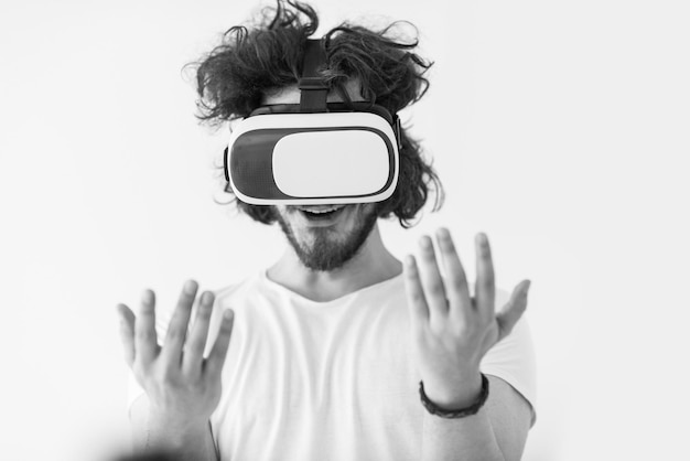 Gelukkige man die ervaring opdoet met het gebruik van een VR-headsetbril van virtual reality, geïsoleerd op een witte achtergrond