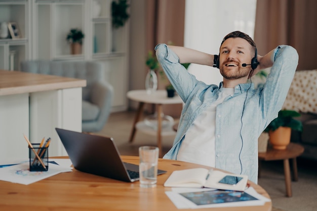 Gelukkige man met headset met microfoon die geniet van online videochat