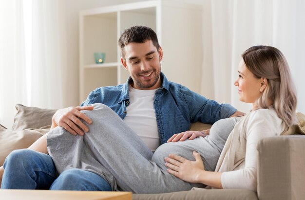 Gelukkige man met zwangere vrouw thuis.