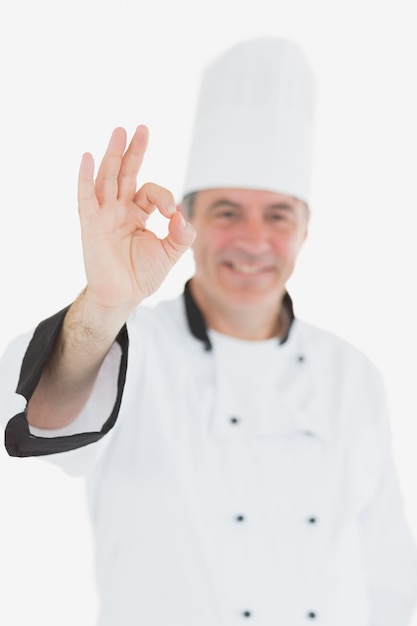 Foto gelukkige mannelijke chef-kok in eenvormig gesturing ok teken