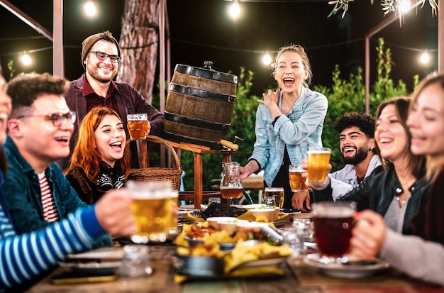 Gelukkige mannen en vrouwen die plezier hebben met drinken in de biertuin