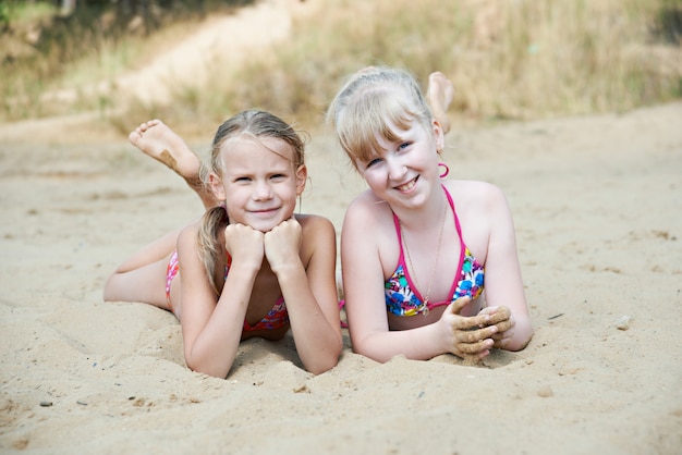 Gelukkige meisjes op zandstrand