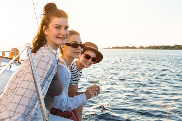 Gelukkige meisjes vrienden op vakantie ontspannen op de zeilboot tijdens het zeilen op zee
