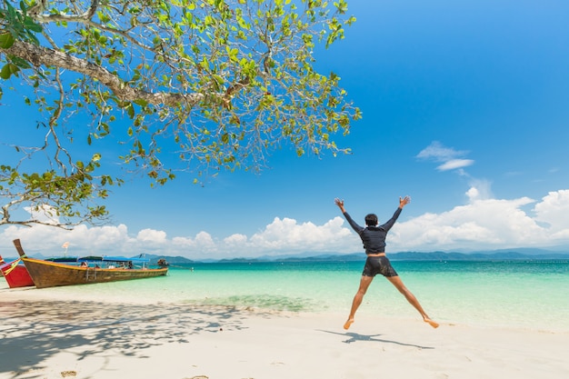 Gelukkige mens bij Wit zandstrand en lang-Staartboot bij Khang Khao Island (Knuppeleiland), de mooie overzeese Provincie van Ranong, Thailand.