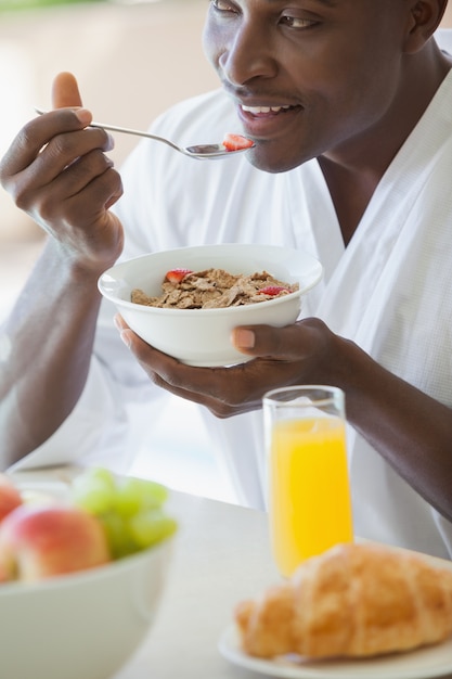 Gelukkige mens die kom graangewas buiten eet