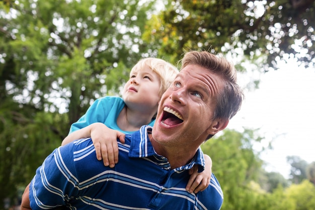 Gelukkige mens die op de rug aan zijn zoon geeft