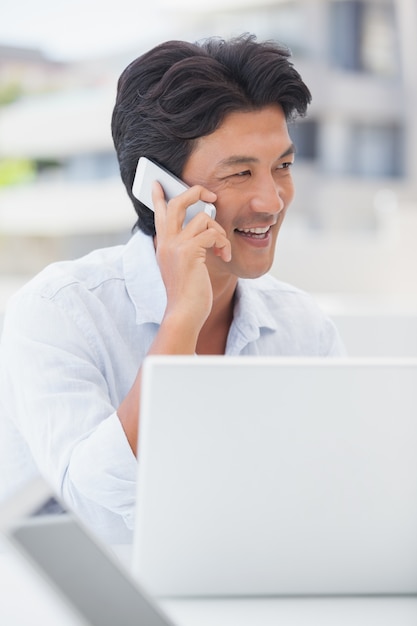 Gelukkige mens die op telefoon spreekt