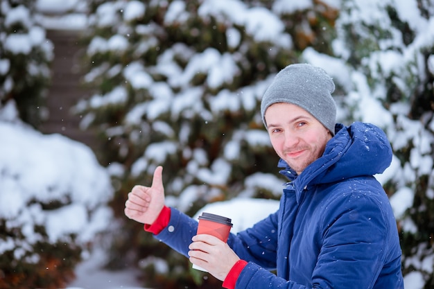 Gelukkige mens het drinken koffie in openlucht in wintertijd